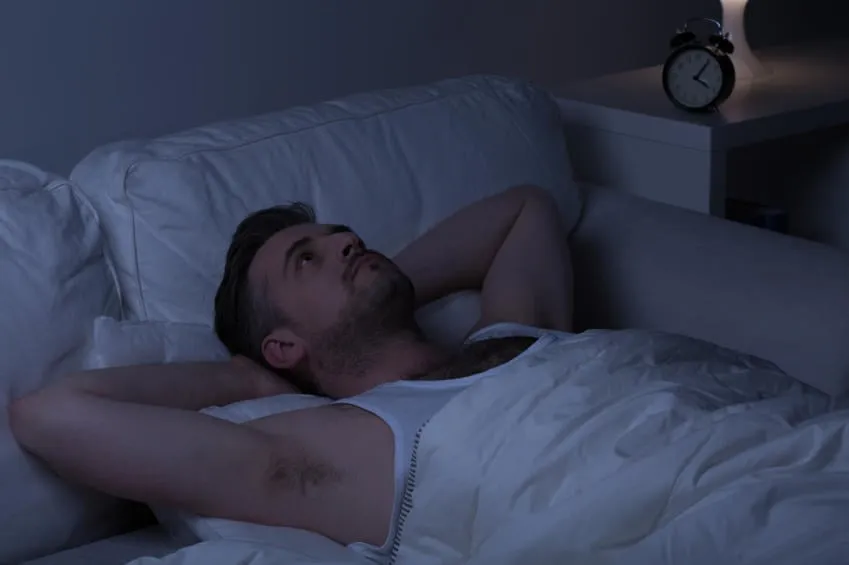 homme regardant le plafond au lieu de dormir