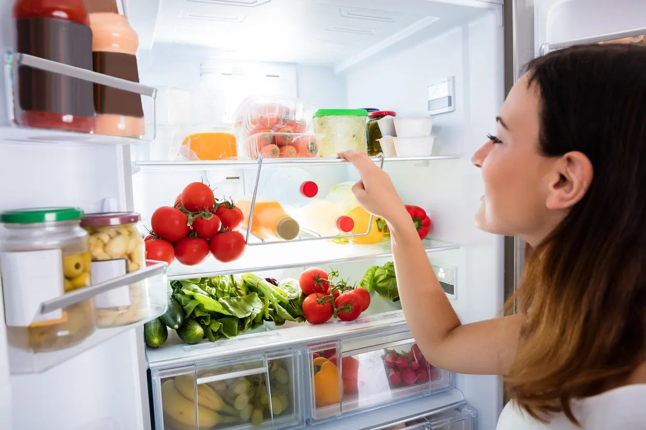 close-up of young woman searching for food in the fridge
