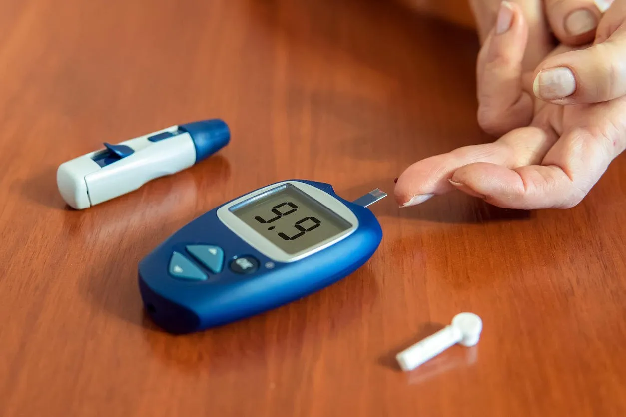 close-up of woman hands testing high blood sugar with glucometer high blood sugar level an elderly woman blood glucose meter and needles for the test lie on a wooden table