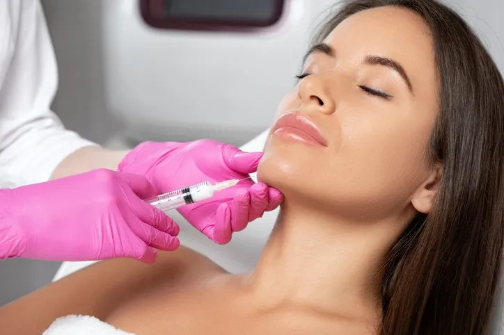 cosmetologist makes lipolytic injections to burn fat on the chin, cheeks and neck of a woman against double chin female aesthetic cosmetology in a beauty saloncosmetology concept