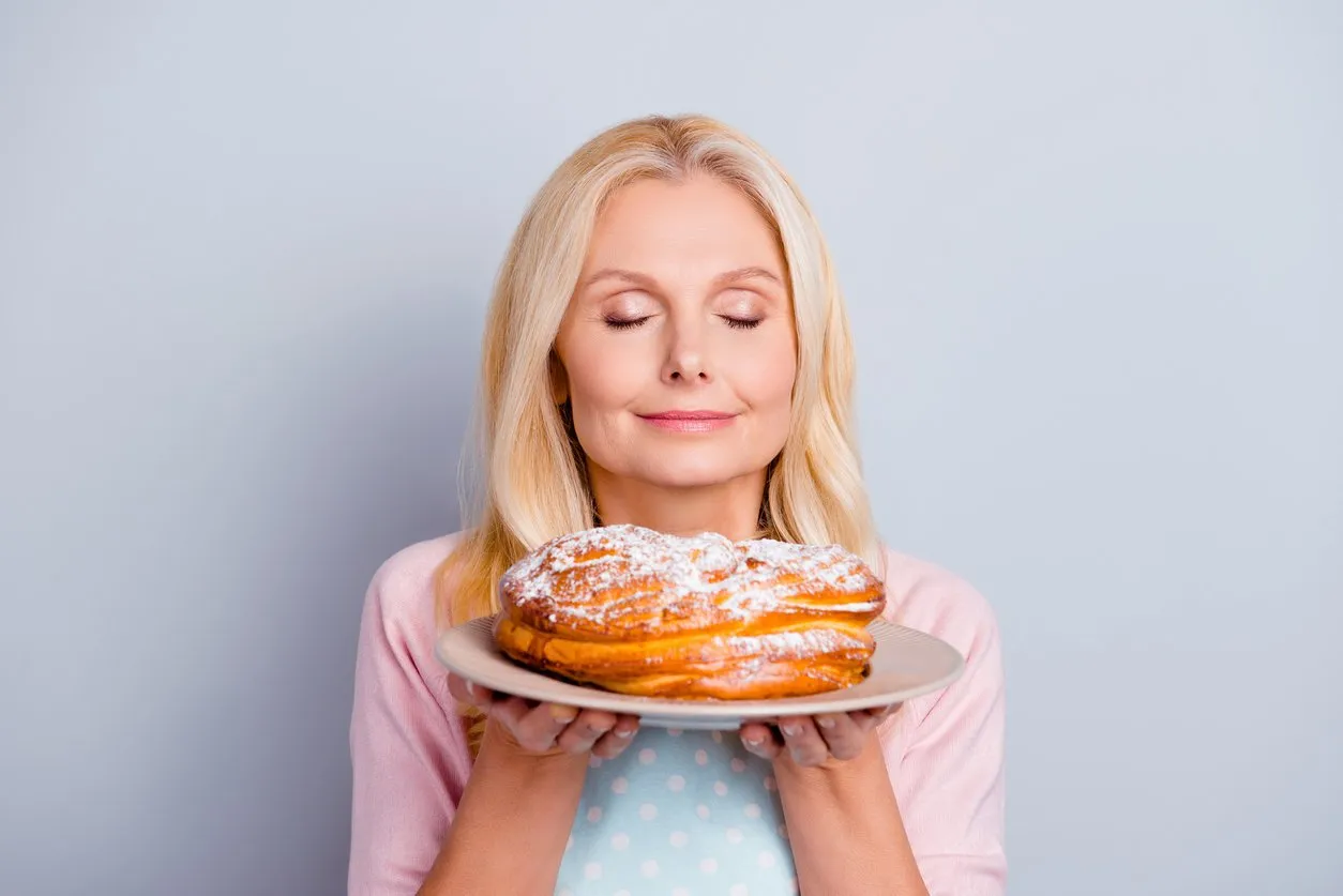 sugar scent aroma aromatic people person concept close up portrait of peaceful calm satisfied cute lovely romantic with modern hairstyle granny smelling fresh tasty cake isolated on gray background