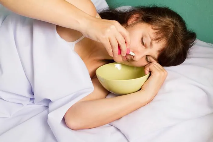woman lying on the bed, washes the nose