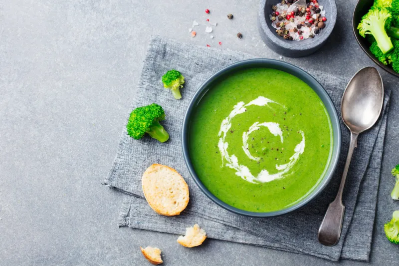 broccoli cream soup in a bowl with toasted bread top view copy space