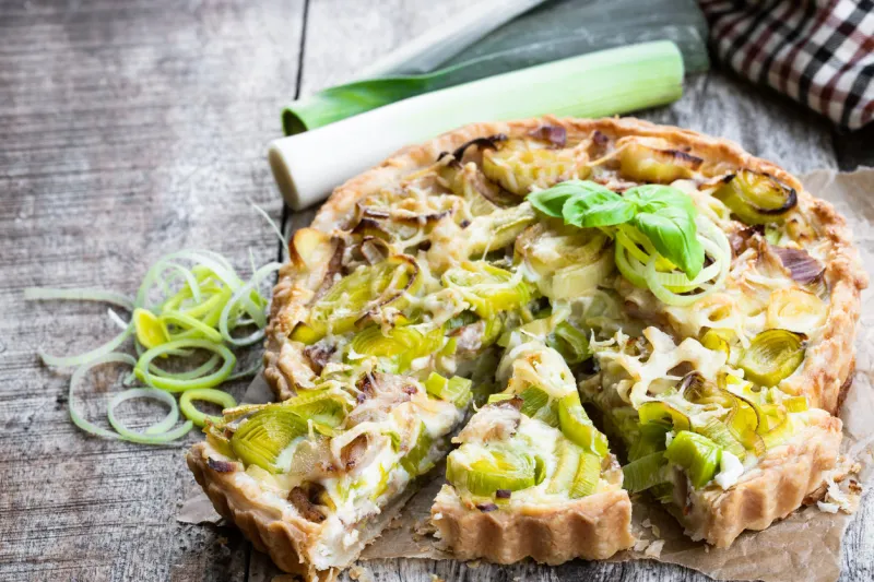 leek tart with bacon and cheese on wooden table