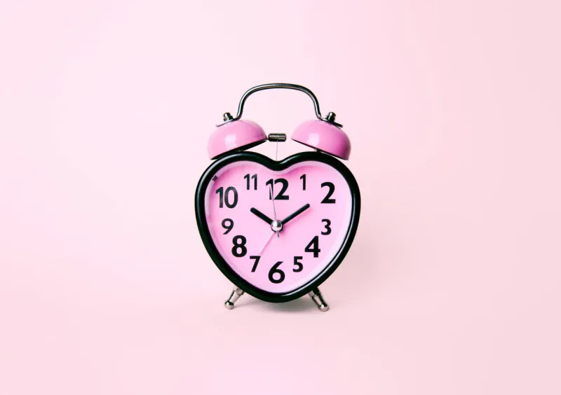 heart shaped clock on pink background valentines day and love and duration concept