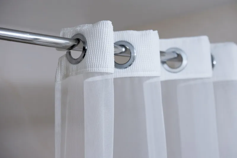 shower curtain hanging from a chrome shower curtain rod