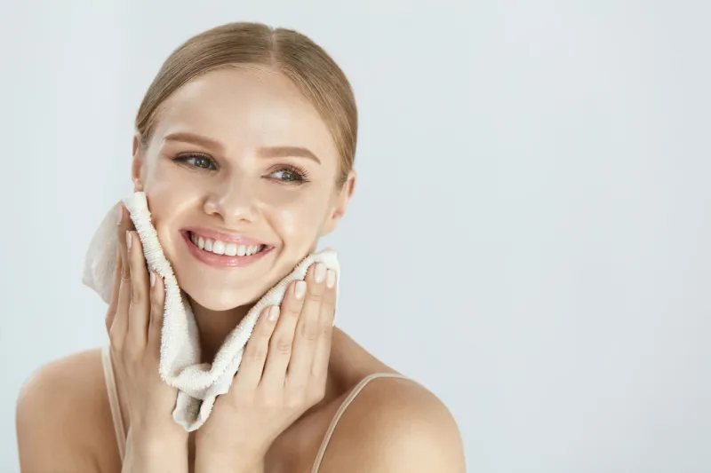 face washing closeup of happy woman drying skin with towel high resolution