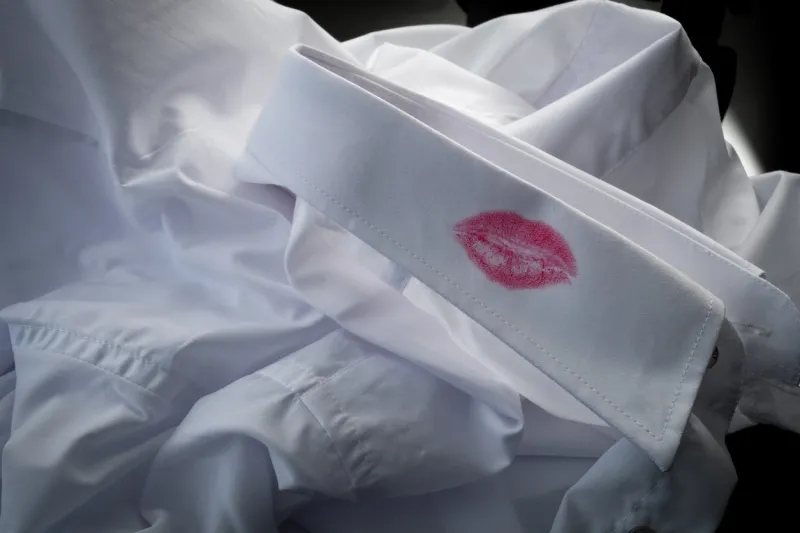 divorce evidence, sexual affair and cheating husband concept with closeup on a shirt with red kiss lipstick of man that is a cheater with copy space
