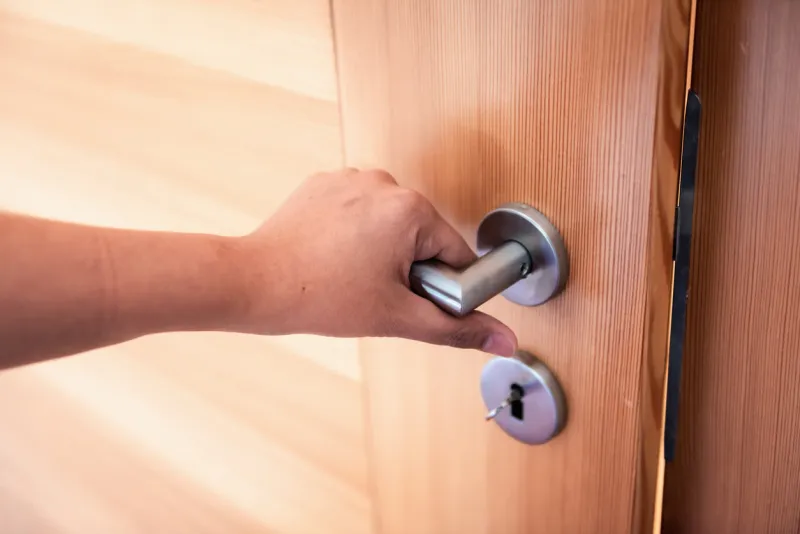 woman hand is holding door knob while opening a door in bedroom, lock security system and access safety of doorway, interior design of doorknob entering to accessibility private room