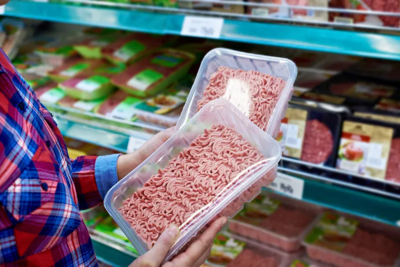 buyer chooses minced meat in a store