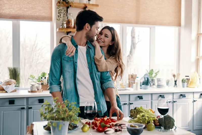 beautiful young couple cooking dinner while standing in the kitchen at home
