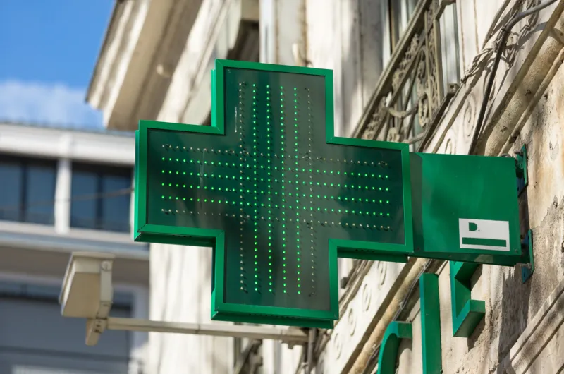 closeup of a green pharmacy sign outside a pharmacy store in france