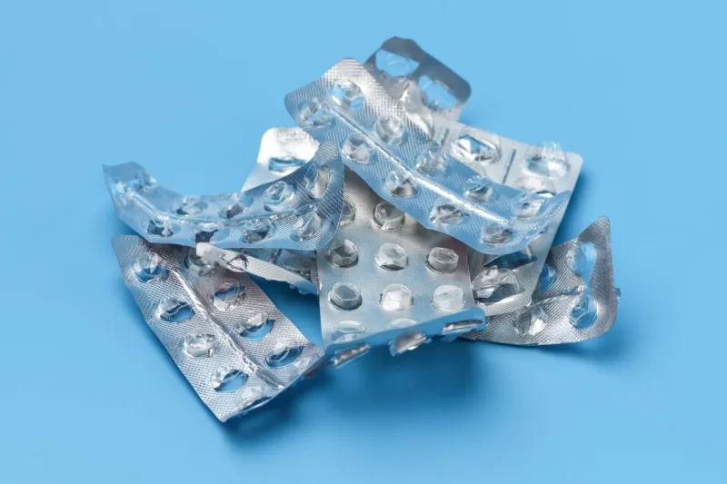 lots of empty pill packs on a blue background medical background