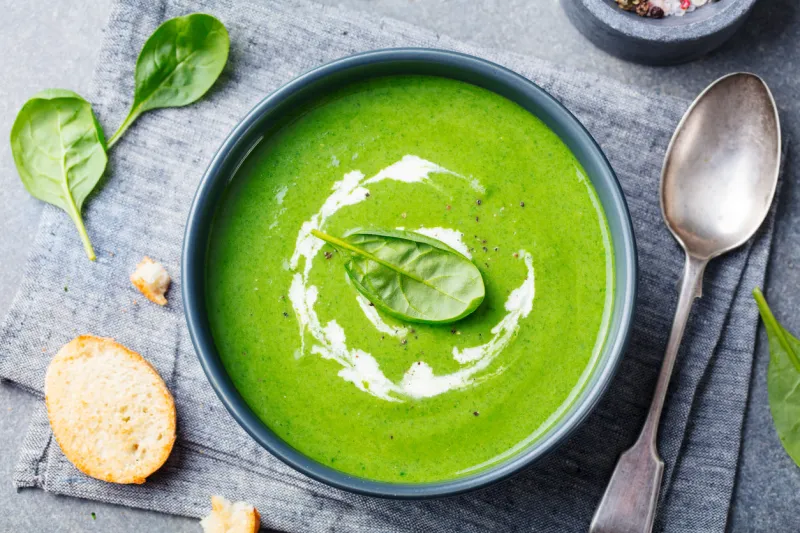 spinach soup with cream in a bowl top view