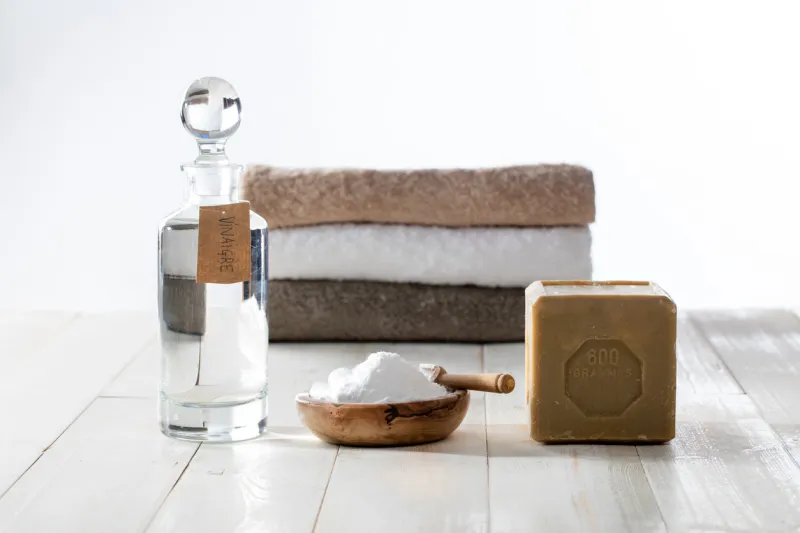 washing green with clean anti-pollution laundry detergents made of sustainable ingredients, traditional soap, white vinegar and baking soda salt on wooden background