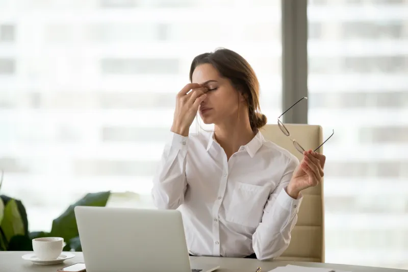 fatigued businesswoman taking off glasses tired of computer work, exhausted employee suffering from blurry vision symptoms after long laptop use, overworked woman feels eye strain tension problem