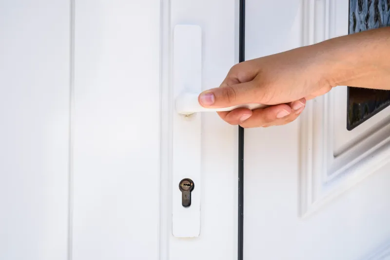 hand holds doorknob on front door pvc