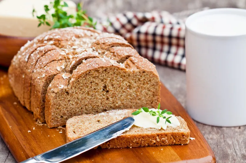 sliced irish stoneground soda bread with butter and thyme on the wooden table