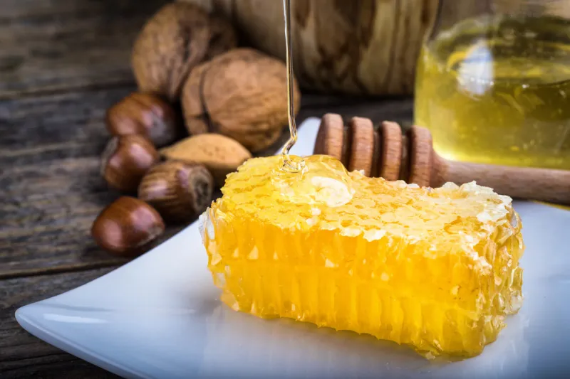 honey dipper and honeycomb, nuts in honey and nuts of various kinds