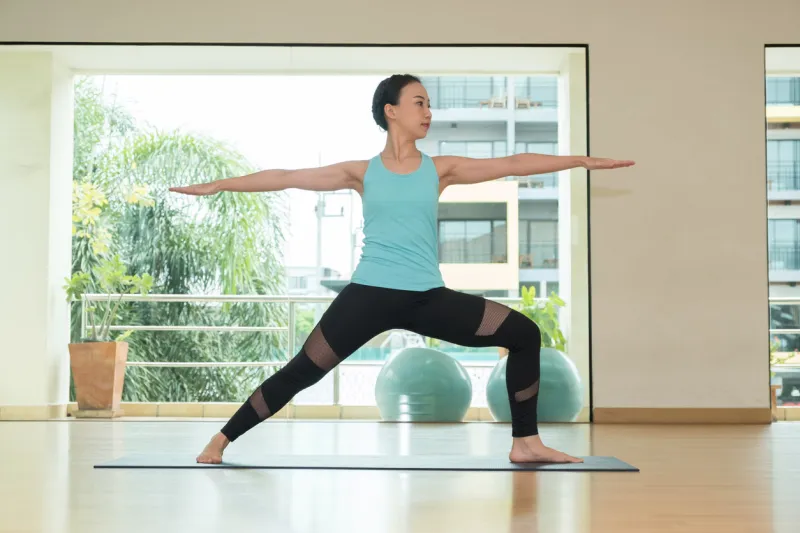 yoga class studio,asian woman master doing warrior ii pose,healthly lifestyle sport