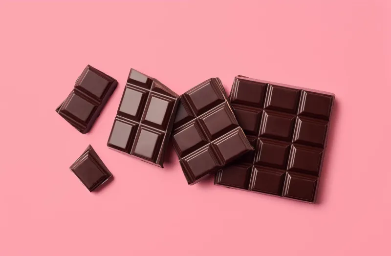dark chocolate on pink background top view