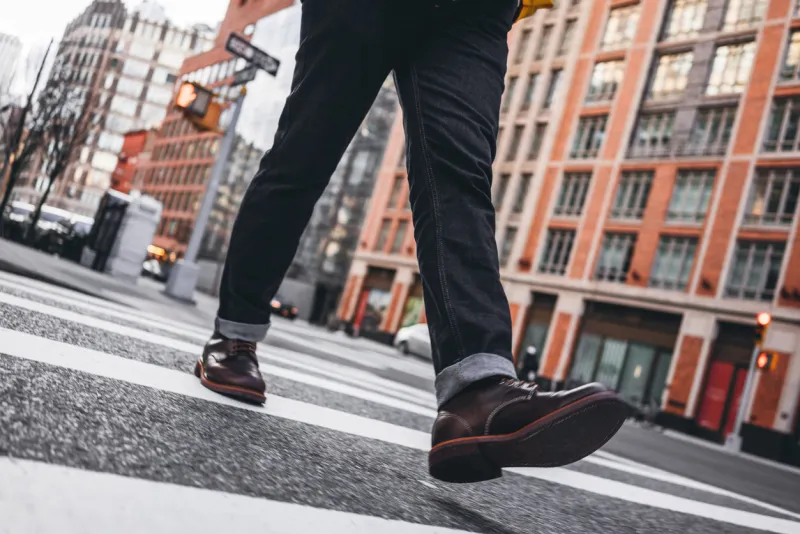 closeup view of man legs wearing shoes crosswalk road