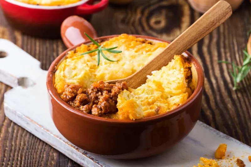 shepherd's pie, traditional british dish with minced meat and mashed potato on rustic wooden table