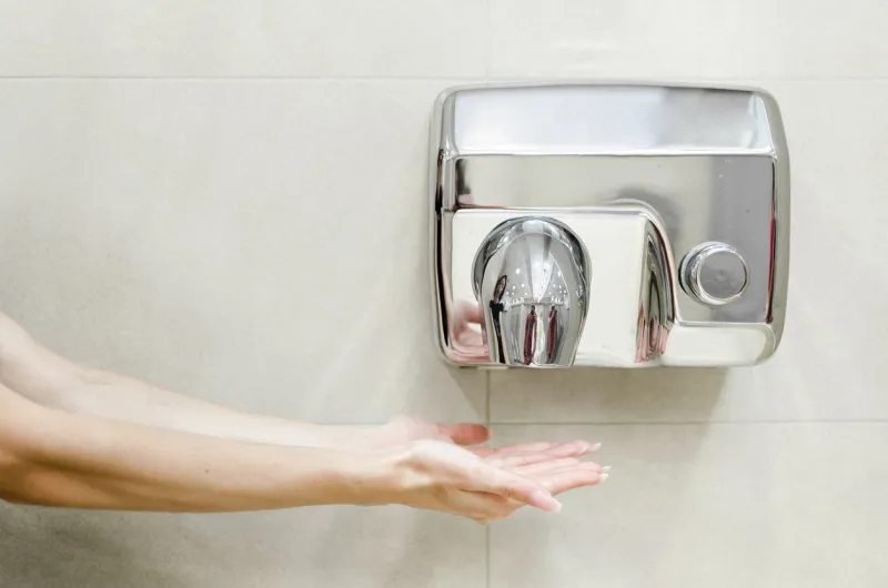 woman dries her hands in the bathroom