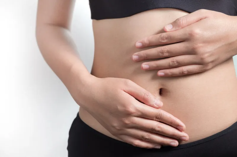 female hands protecting the stomach on white background