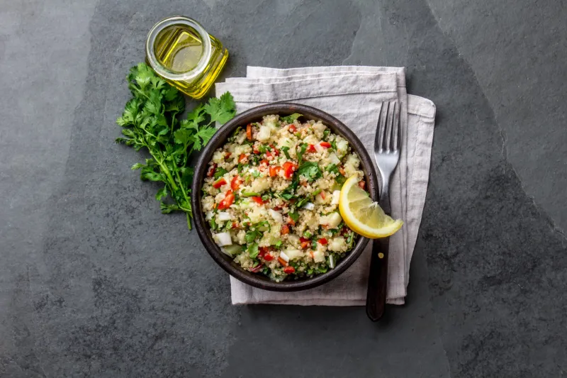 traditional peruvian quinoa quinua salad in clay bowl, slate gray background