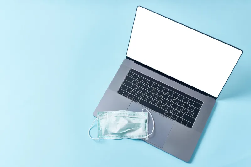 flatlay with laptop template with empty screen and protection mask working from home at the time of coronavirus outbreak concept