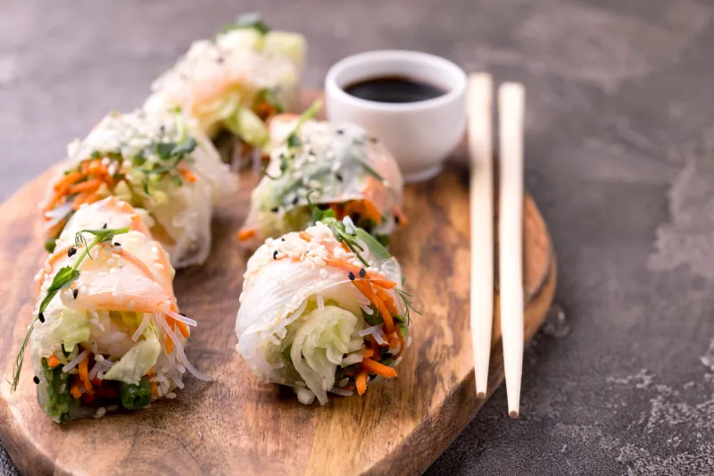 fresh assorted vietnamese spring rolls with shrimps and vegetables on dark background copyspace