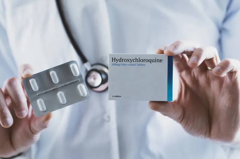 doctor holding hydroxychloroquine drug