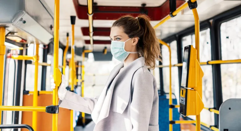 woman wearing surgical protective mask going to work