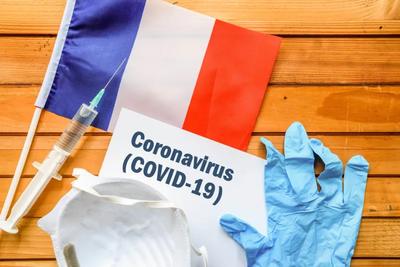 flag of france , vaccine, face mask for virus, glove and paper sheet with words coronavirus covid-19