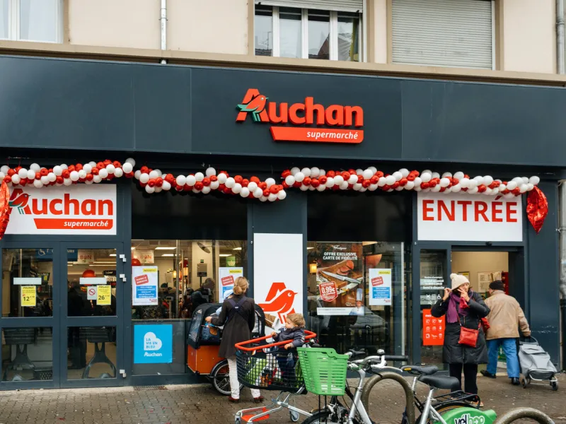 strasbourg  new auchan supermarket entrance in french neighborhood on a winter snow day with customers exiting the entrance of the store