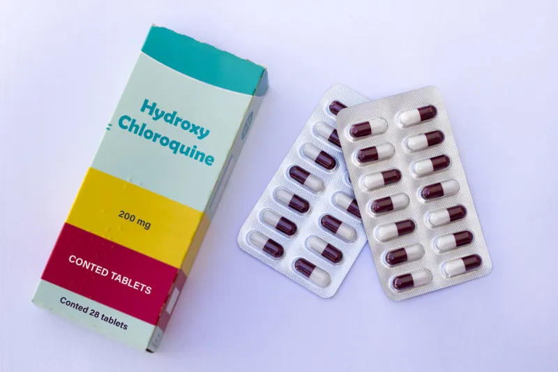medical concept - hydroxychloroquine cloroquina medicine box with pills on white background