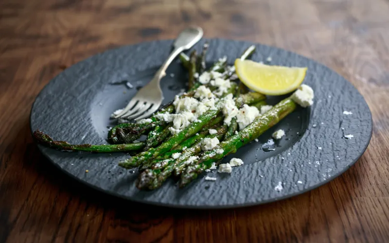 grilled asparagus salad with feta cheese on slate effect plate