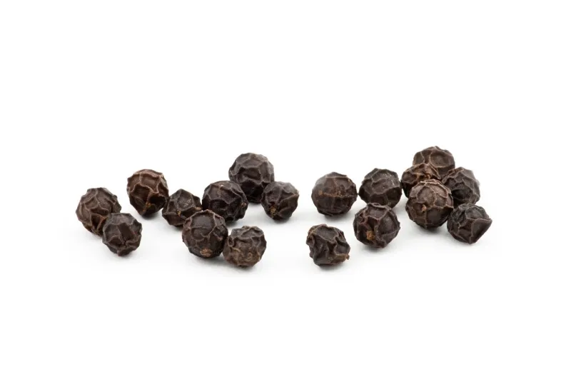 black peppercorns against a white background