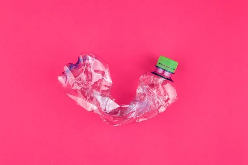 crushed pet bottle closeup on vivid pink purple background plastic collection fashion attractive concept