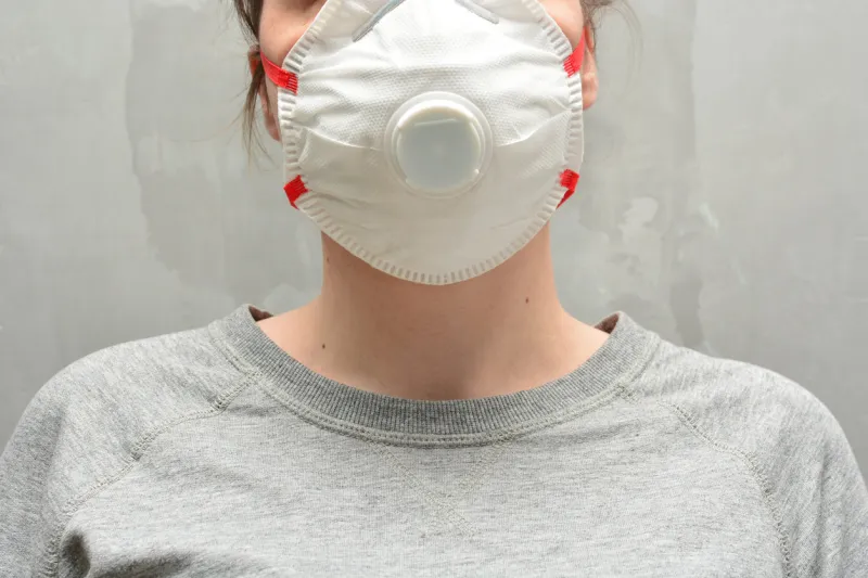 young woman wearing a protective mask or respirator banner with anti coronavirus, virus and flu concept