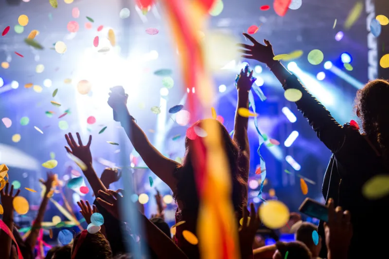 crowd of people raising their hands in the air on a music festival