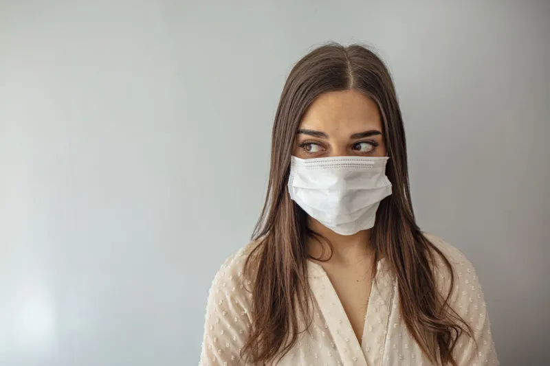 woman in a medical mask close-up on a gray background healthy lifestyle, ill sick disease treatment concept mock up copy space epidemic, dangerous and deadly virus, infection concept