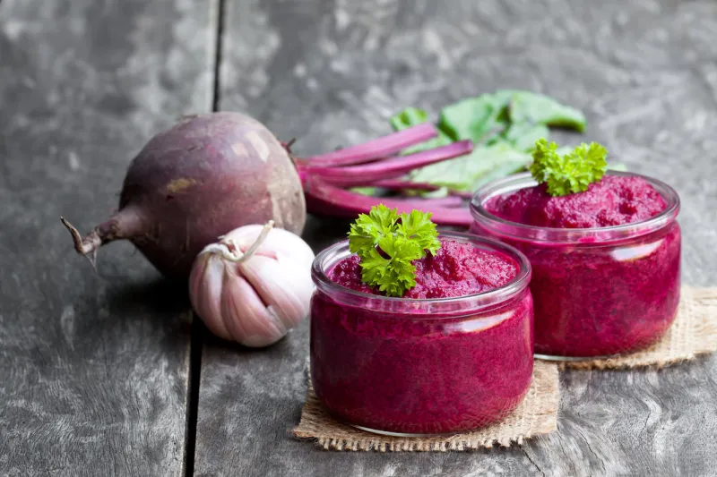 beetroot puree in glass jars on wooden table