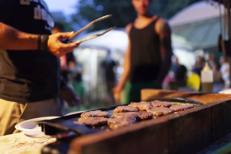 friends making barbecue in the evening at a party
