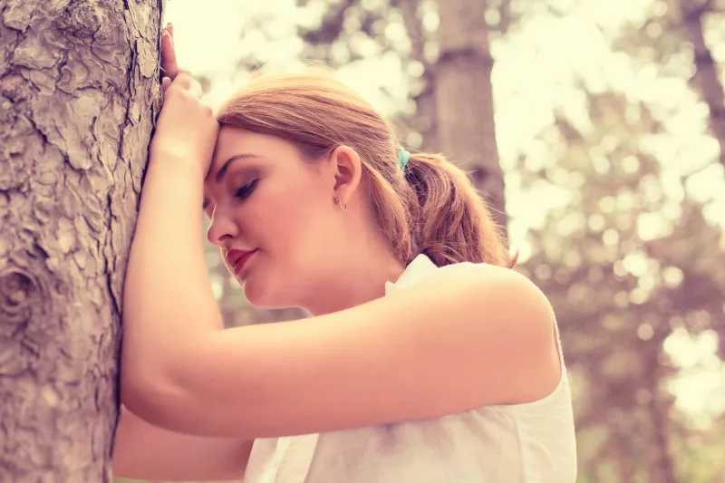 portrait stressed sad young woman standing outdoors on summer day in park