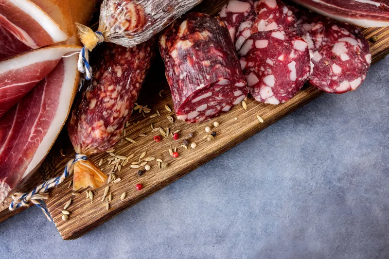 traditional sausage , sausage with mold and spanish ham( bellota, jamon) sliced sausage salami on wooden board with spices  pepper and fennel close-up top view