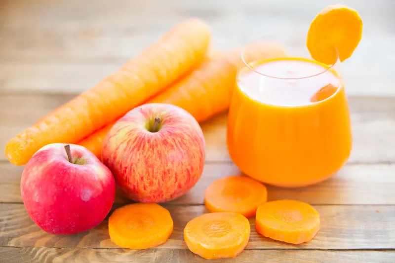 carrot juice in glass on wooden table