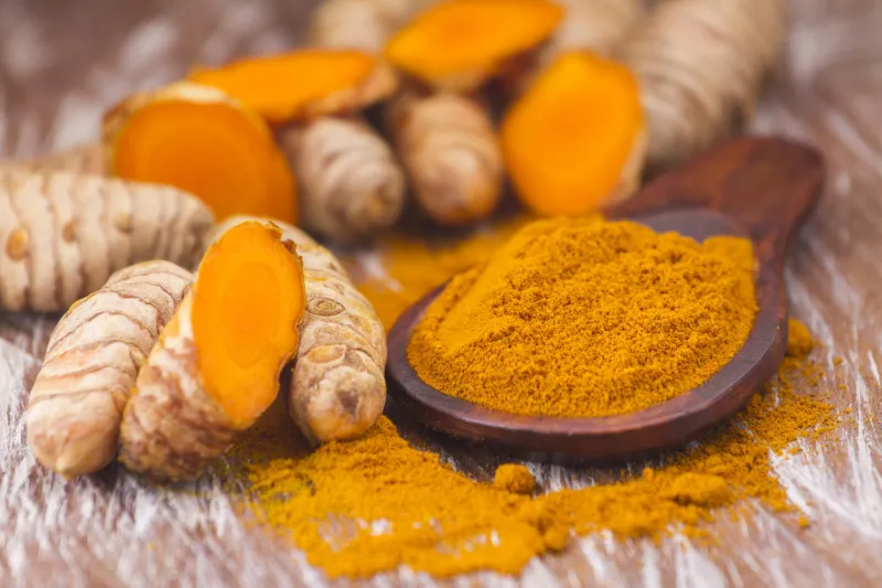 turmeric powder and roots, asian origin plant containing curcumin has very powerful anti-inflammatory and antioxidant properties