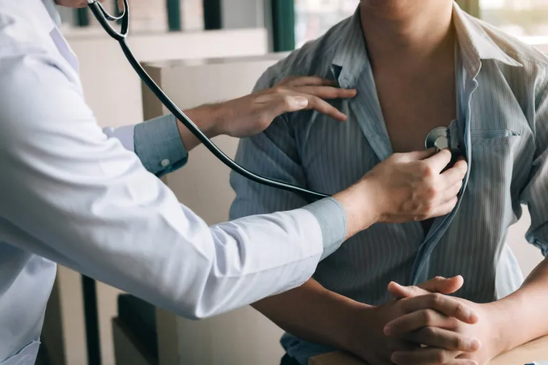asian doctor is using a stethoscope listen to the heartbeat of the elderly patient